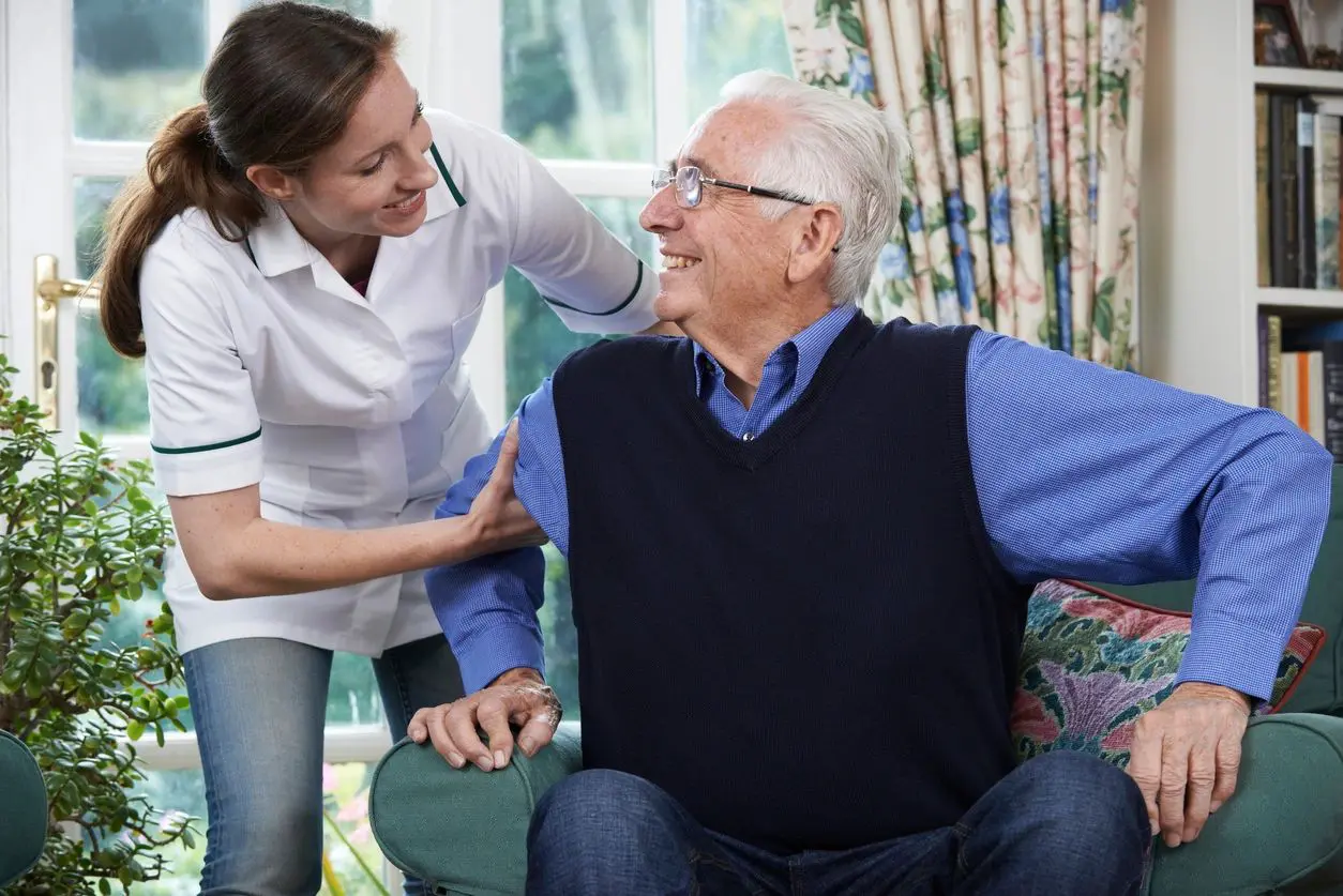 qtq80-vwRFwN A woman is helping an older man sit in his chair.